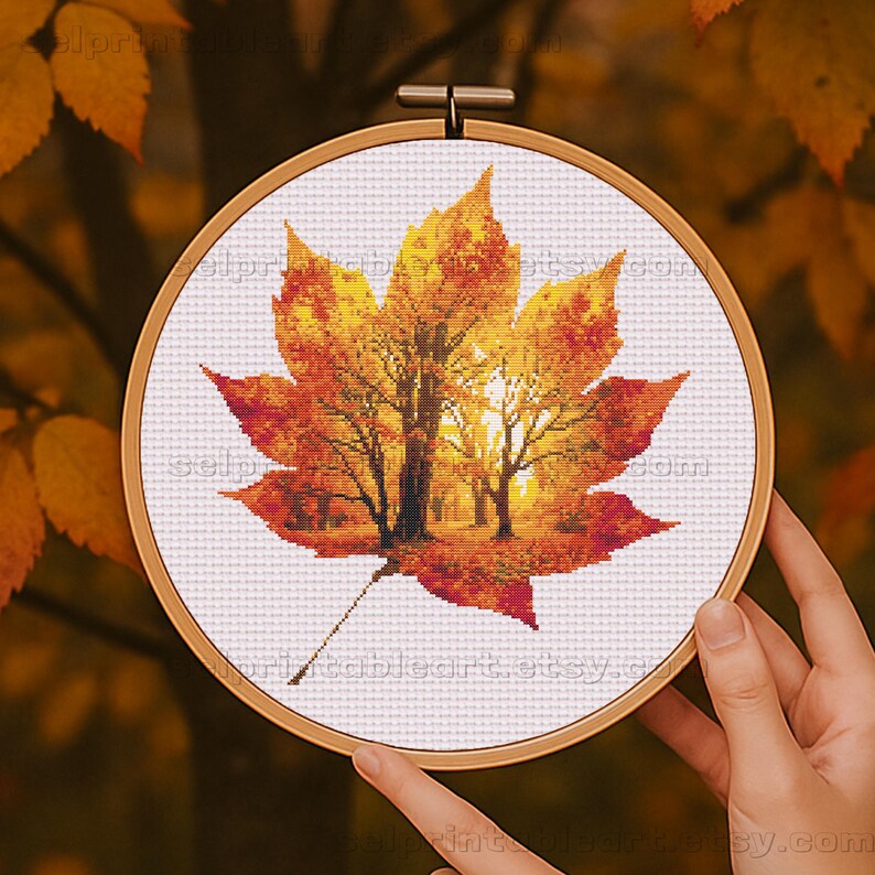 Romantic autumn forest landscape cross stitch inside a maple leaf design - Golden fall leaf embroidery pattern featuring a glowing woodland scene - Nature-inspired autumn decor – maple leaf cross stitch with forest sunlight - Rustic woodland fall embroidery, perfect for cozy seasonal wall art - Detailed maple leaf cross stitch pattern with a warm, romantic autumn theme