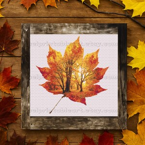Romantic autumn forest landscape cross stitch inside a maple leaf design - Golden fall leaf embroidery pattern featuring a glowing woodland scene - Nature-inspired autumn decor – maple leaf cross stitch with forest sunlight - Rustic woodland fall embroidery, perfect for cozy seasonal wall art - Detailed maple leaf cross stitch pattern with a warm, romantic autumn theme