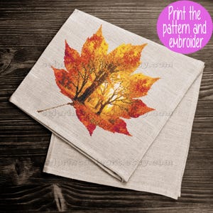 Romantic autumn forest landscape cross stitch inside a maple leaf design - Golden fall leaf embroidery pattern featuring a glowing woodland scene - Nature-inspired autumn decor – maple leaf cross stitch with forest sunlight - Rustic woodland fall embroidery, perfect for cozy seasonal wall art - Detailed maple leaf cross stitch pattern with a warm, romantic autumn theme