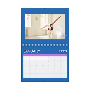 May include: A blue wall calendar for 2026, featuring a gymnast performing a handstand. The calendar shows the month of January with a grid of dates. The calendar is designed with a spiral binding and a hanging loop.