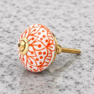 Pomelli in ceramica arancione dipinti a mano con motivi floreali, maniglie rotonde per cassetti di mobili.