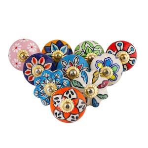 May include: A collection of colorful ceramic cabinet knobs with floral designs. The knobs feature various colors including pink, blue, orange, and green, with gold-colored metal accents. Each knob has a unique hand-painted pattern.
