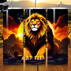 May include: A tumbler featuring a majestic lion with a cigarette, set against a vibrant sunset backdrop. The design includes a sunflower field and mountains, with the text "Woby-Soby" at the top. The tumbler is cylindrical and has a straw.