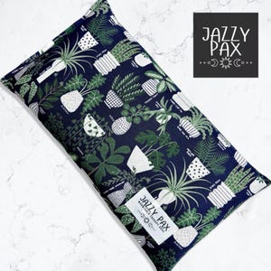 May include: A navy blue rectangular Jazzy Pax warm/cold therapy bag. The bag is patterned with green and white potted plants and botanical illustrations. The Jazzy Pax logo is visible on a white label.