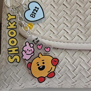 BT21 Charm Clip featuring Tata, RJ, Koya, Mang, Chimmy, Shooky Each with a Mini BT21 Friend, Name, Heart, Crystal Gem on Swivel Clasp