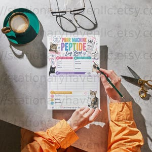 Può includere: Un registro Purr Machine Peptide Log Book con illustrazioni di gatti, icone mediche e sezioni compilabili per il monitoraggio dei farmaci. La pagina presenta testo colorato, una griglia per i record di somministrazione e spazio per note.