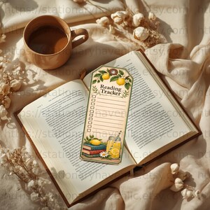 Puede incluir: Un marcapáginas de papel rectangular con una ilustración de limones y hojas en la parte superior, el texto Reading Tracker, una lista de diez casillas con líneas y un gráfico inferior con libros, un limón y un vaso de limonada.