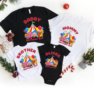 K&ouml;nnte beinhalten: Vier Familien-Geburtstagsshirts. Ein schwarzes T-Shirt mit der Aufschrift "DADDY of the BIRTHDAY BOY". Ein wei&szlig;es T-Shirt mit der Aufschrift "MOMMY of the BIRTHDAY BOY". Ein wei&szlig;es T-Shirt mit der Aufschrift "BROTHER of the BIRTHDAY BOY". Ein schwarzer Body mit der Aufschrift "OLIUER BIRTHDAY BOY".