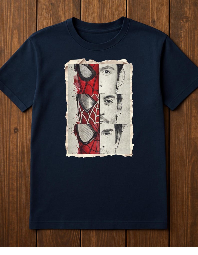 Op de afbeelding: Marineblauw T-shirt met een grafische afbeelding van Spider-Mans masker en gezicht. Het ontwerp is verdeeld in drie secties, elk met een andere Spider-Man-iteratie. De illustratie is geplaatst tegen een vintage achtergrond.