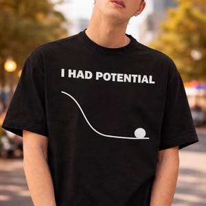 May include: Black t-shirt with the white text "I HAD POTENTIAL" above a white line and ball graphic. The shirt is worn by a person wearing sunglasses and a black cap.