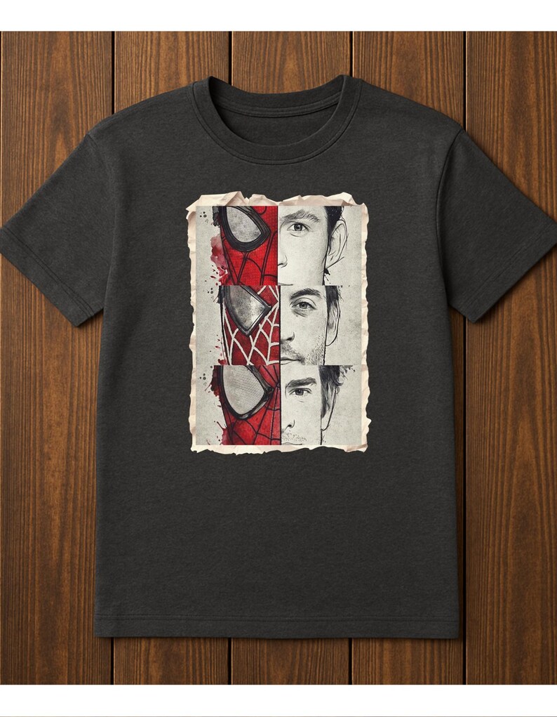 Op de afbeelding: Donkergrijs t-shirt met een afbeelding van Spider-Mans masker en de gezichten van drie acteurs. Het ontwerp is verdeeld in secties, met het Spider-Man masker in rood en zwart, en de gezichten van de acteurs in zwart en wit.