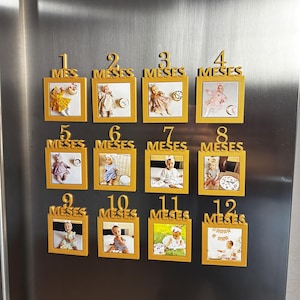 Peut inclure: Un ensemble de douze cadres photo magnétiques carrés de couleur dorée disposés en trois rangées de quatre. Chaque cadre présente un chiffre en relief de 1 à 12 et le mot MESES au-dessus de la photo, montrant un enfant à différents âges.
