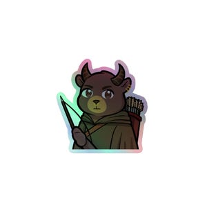 May include: Holographic sticker featuring a cartoon bear with horns, a bow and arrow, and a quiver of arrows. The bear is wearing a green cloak and has a determined expression. The sticker has a shiny, iridescent finish.