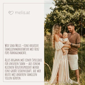 May include: A family portrait featuring a couple and a baby in a natural outdoor setting. The woman wears a long, flowing cream-colored dress, while the man wears a brown shirt and shorts. The image includes the text "melis.at" and a description in German.