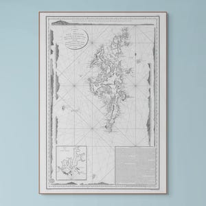 Puede incluir: Impresión enmarcada de un mapa antiguo que presenta una representación detallada en escala de grises de una región costera. El mapa incluye líneas intrincadas, texto y una rosa de los vientos, sobre un fondo claro. La impresión está dentro de un marco simple y claro.