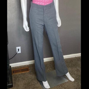 May include: Grey straight-leg trousers with a pink lace top.