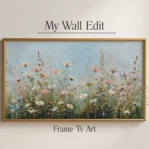 May include: A framed floral painting with a gold-coloured frame. The artwork features a field of wildflowers in shades of pink, white, and yellow against a light blue background. The text "My Wall Edit" and "Frame Tv Art" are displayed on the image.