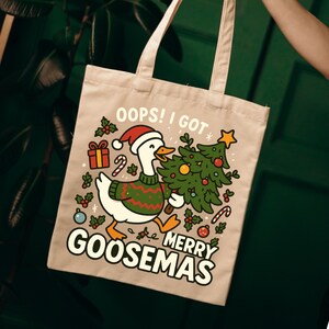 Peut inclure: Sac fourre-tout beige avec un dessin d'oie de dessin animé portant un bonnet de Père Noël et un pull vert, tenant un sapin de Noël. Le texte dit "OOPS! I GOT MERRY GOOSEMAS" avec des graphismes de vacances.