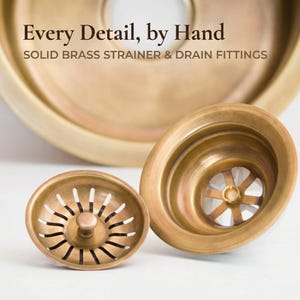 Close-up detail of TerraFez handcrafted solid brass strainer basket and drain flange fittings, showing artisan craftsmanship and matching patina finish.