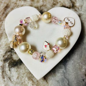 25 cm langes Armband mit großen Perlen, hellrosa Kristallen, Liebesbrief-Charm, Perlenschleifen-Knopf und Herz-Charm. Ein perfekter Valentinstag!