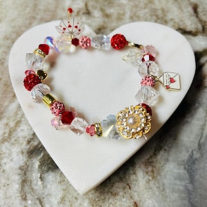 Charmantes 10 "Valentinstagsarmband mit Regenschirm- und Liebesbriefanhänger, rosa / roten Perlen, Kristallakzenten und Strass- / Perlenknopf.