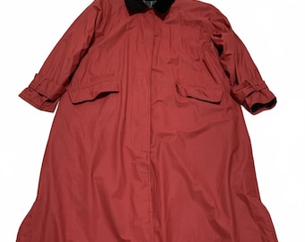 May include: A long, red raincoat with a black velvet collar and cuffs. The coat has two front pockets and a button-up closure. The sleeves have adjustable cuffs.