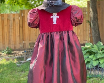 A taffeta maroon color girl dress and a witch hat