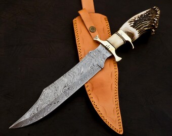 May include: A hunting knife with a patterned steel blade and a white antler handle. The knife is in a brown leather sheath.