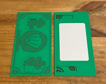 May include: Two rectangular green plastic items. The left item features a dark green dollar sign at the top and bottom with a central shell icon. The right item has a large white rectangular center panel with dark green corner accents.