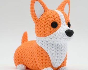 May include: A 3D printed figurine of a Corgi dog with a textured, knit-like surface pattern. The dog is orange and white with black eyes and a black nose, featuring pointed ears, a short tail, and small white paws.