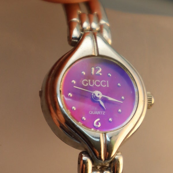 Montre Gucci vintage pour femme avec cadran rose et violet réfléchissant