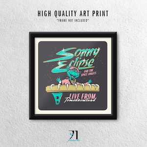 May include: A framed art print with the text "Sonny Eclipse and the Space Angels" in teal and gold. The print features a cartoon alien character and the words "Live From Tomorrowland". The frame is black.