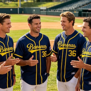 May include: A group of individuals wearing dark blue baseball jerseys with yellow trim and the word Bananas printed in yellow script across the chest. The jerseys feature the number 36 in yellow and a small American flag patch on the sleeve.