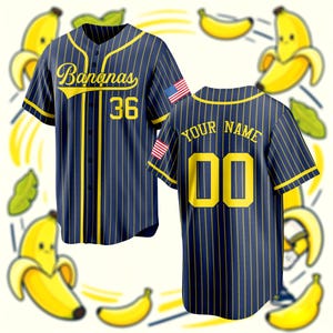 May include: A navy blue baseball jersey with yellow pinstripes, featuring the word Bananas in yellow script, the number 36, and an American flag patch on the sleeve. The back displays the text YOUR NAME and the number 00 in yellow lettering.