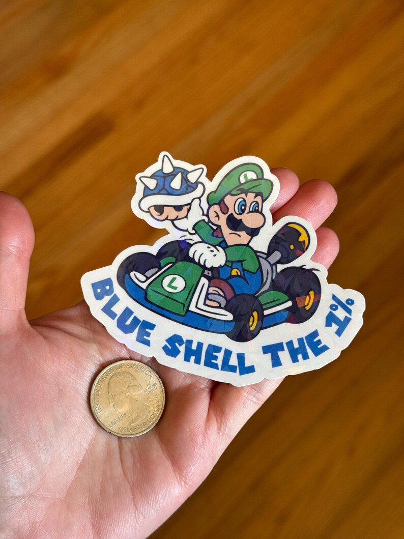 May include: A sticker featuring a green Mario character driving a blue kart with a blue shell in the back. The text "Blue Shell the 1%" is written around the sticker.