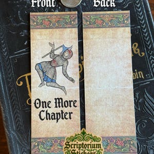 May include: Two medieval-themed bookmarks. The front bookmark features an illustration of a knight with an axe and the text "One More Chapter." The back bookmark is blank. The bookmarks have a decorative border with floral elements.