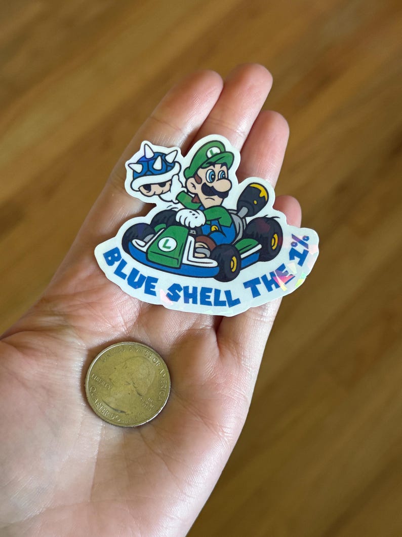 May include: A blue and green sticker with a cartoon image of Mario and a blue shell. The sticker says "Blue Shell The 7% "