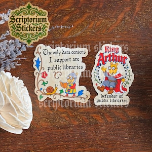 May include: Two die-cut stickers featuring Arthur Read. One sticker shows Arthur in medieval armor reading a book with the text, The only data centers I support are public libraries. The other shows Arthur as King Arthur with the text, King Arthur defender of public libraries.