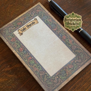May include: A notepad with a decorative border and the words "Side Quests" on a banner. The border features a floral and foliate design in shades of green, red, and blue. A black pen and a sticker with the text "Scriptorium Stickers" are also present.