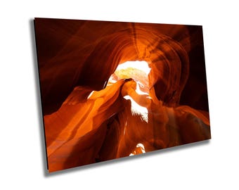 May include: A narrow canyon with smooth, orange-red rock walls. Sunlight streams through the opening at the top, illuminating the canyon's interior.
