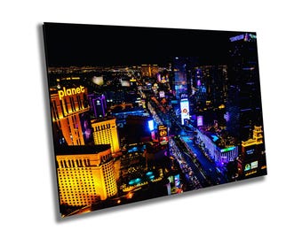 May include: An aerial view of a city at night with brightly lit buildings and streets. The image features a large sign that reads "planet" in yellow letters.