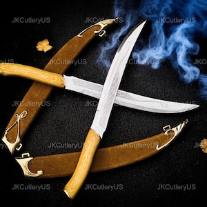 May include: Two crossed daggers with wooden handles and ornate silver blades. The daggers are in brown sheaths with gold-colored accents. The background is black with a blue smoky effect.