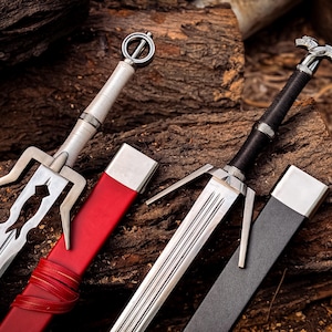 May include: Two swords with leather sheaths. The sword on the left has a silver blade with a black handle and a red sheath. The sword on the right has a silver blade with a black handle and a black sheath.