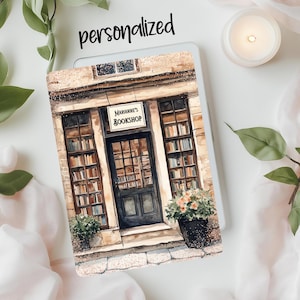 May include: A watercolor painting of a bookstore storefront with a sign that reads "Marianne's Bookshop". The storefront has a large window display filled with books and a wooden door with a glass panel. There are potted plants in front of the store.