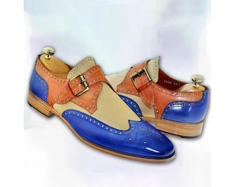 May include: A pair of two-tone leather shoes with a blue toe, tan center, and orange accents. The shoes feature a buckle closure and decorative perforations. The heels are light brown.