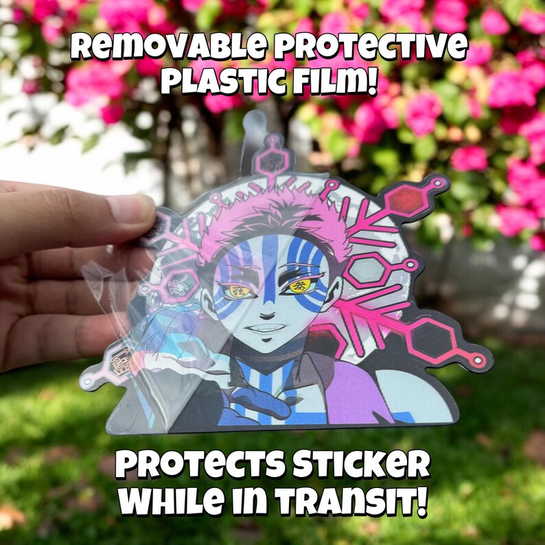 May include: A removable protective plastic film covers a colorful anime sticker featuring a character with pink hair and blue and white markings. The sticker has a snowflake design and the text "REMOVABLE PROTECTIVE PLASTIC FILM!" and "PROTECTS STICKER WHILE IN TRANSIT!"