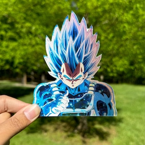 May include: A blue and white anime character with spiky hair and a determined expression. The character is wearing a blue and white suit with a silver belt. The background is blurred and green.