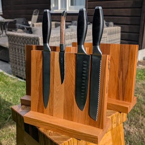 Peut inclure: Un bloc de couteaux en bois avec quatre couteaux. Les couteaux ont des manches noirs et des lames argentées. Le bloc de couteaux est en bois brun clair et a un design simple et moderne. Les couteaux sont de tailles et de styles de lames variés.