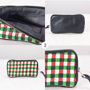 May include: A black leather zippered pouch with a checkered pattern in red, green, and white. The pouch is open to show the black lining.