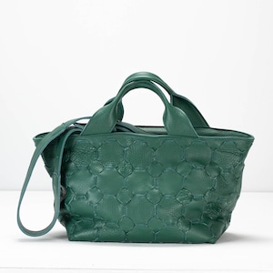 May include: A dark green leather tote bag with a quilted pattern and a top handle. The bag has a detachable shoulder strap.